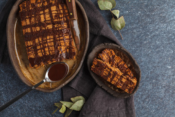 Vanilla vegan aquafaba cake with chocolate glaze in a dark dish, top view. Healthy vegan food concept.