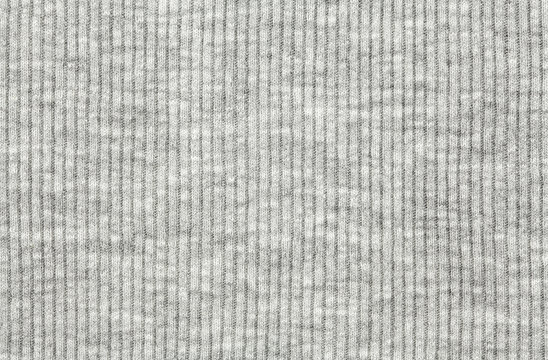 Real white-grey knitted fabric made of synthetic fibres textured background.
