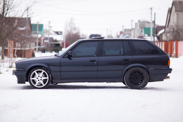 Old, black, German family car side view in winter