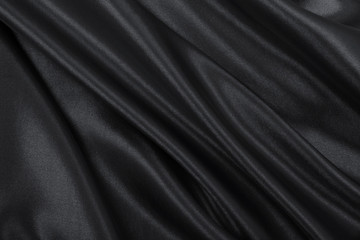 Smooth elegant dark grey silk or satin texture as abstract background. Luxurious background design
