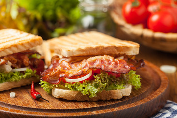 Toasted sandwich with bacon, tomato, cucumber and lettuce.