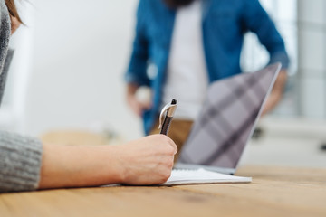 Fototapeta premium Businesswoman writing notes at her desk