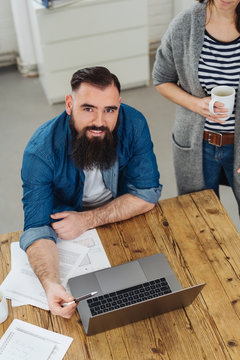 Bearded modern businessman working at a laptop