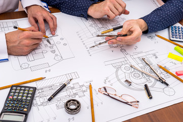 Two engineers discussing an engineering drawing office
