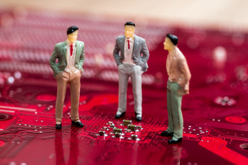 Three businessmen discuss motherboard . close up