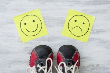 Sneakers, choice, hand drawing unhappy and happy smileys.