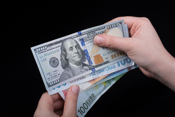 Hand holding American dollar  isolated on black background