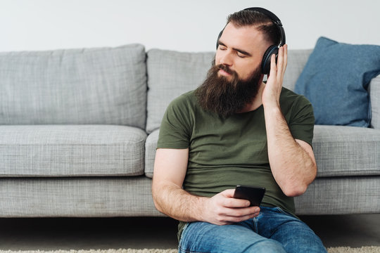Bearded man sitting listening to music
