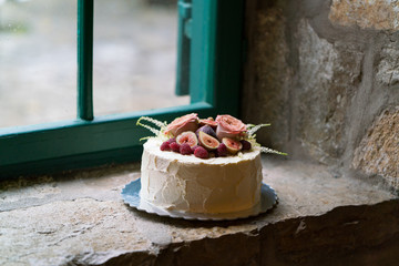 Homemade wedding cake decorated with flowers and fruits