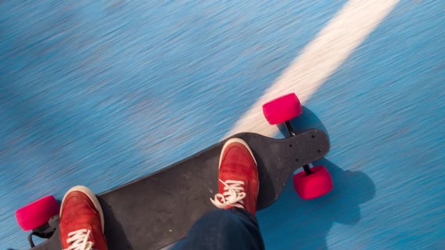 a man's feet on an electric skateboard as it moves along the ground