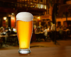 cold glass with beer on the background of a outside bar.