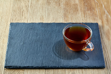 Cup of tea with meringues on a wooden background, top view