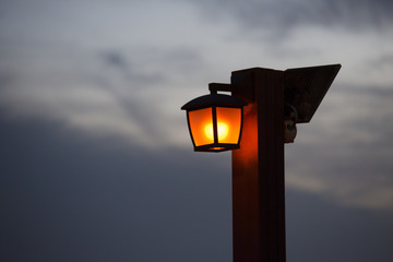 Lantern on a wooden pole evening sky background.