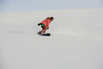 Fototapeta na wymiar Professional male snowboarder sliding on the mountain slope