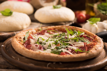 Italian Pizza with rocket salad on wooden table
