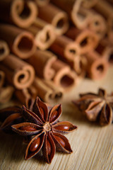 Fototapeta na wymiar shelves of cinnamon and anise stars in dark backgrounds on a wooden background