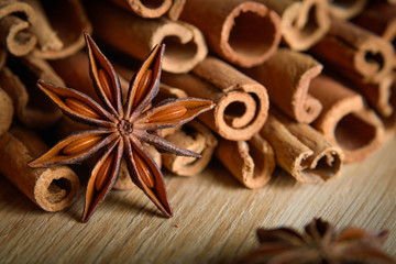  shelves of cinnamon and anise stars in dark backgrounds on a wooden background