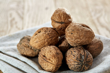 A stack of walnuts piled together and on rustic wooden background, shallow depth of field, selective focus