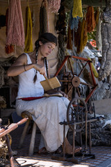 Portrait of a young woman, carding wool at a street market