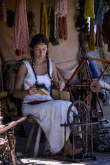 Portrait of a young woman, carding wool at a street market
