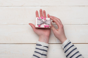 Gift placed on light wooden background, top view.