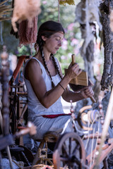 Portrait of a young woman, carding wool at a street market