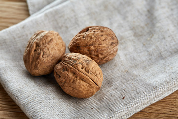 A stack of walnuts piled together and on rustic wooden background, shallow depth of field, selective focus