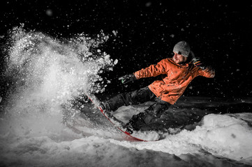 Young freeride snowboarder jumping in snow at night - obrazy, fototapety, plakaty