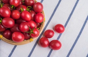 Naklejka na ściany i meble Many cherry tomatoes packed in bamboo basket