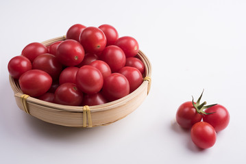 Many cherry tomatoes packed in bamboo basket