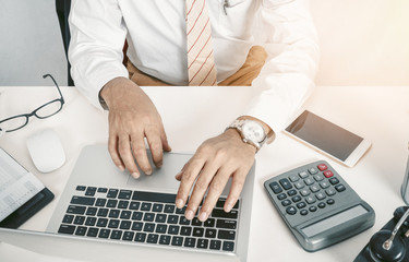Businessman using computer with hands typing on a keyboard
