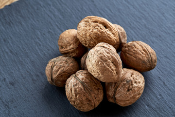 A stack of walnuts piled together and isolated on dark background, shallow depth of field, selective focus