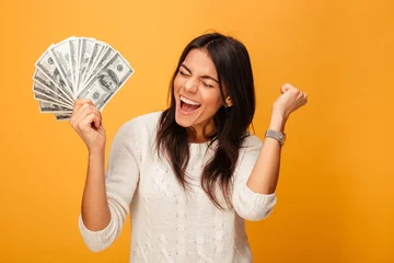 Fotobehang Portrait of a cheerful young woman holding money © Drobot Dean
