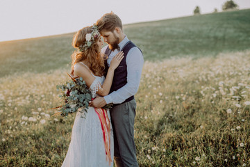 Beautiful bride and groom at sunset in green nature.