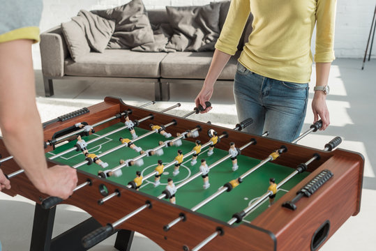 cropped image of couple playing table football at home