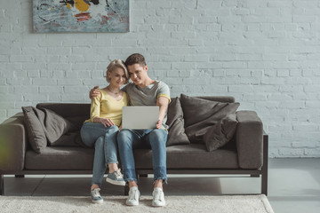 Obraz premium affectionate couple watching movie at laptop at home