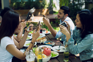 Women and friends Is using a phone Between meals
