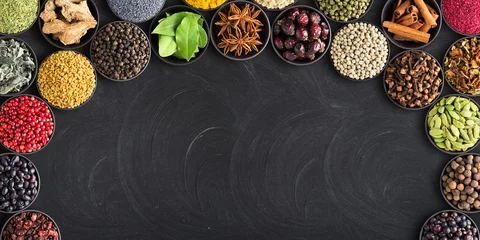 Zelfklevend Fotobehang set of spices on  black table with empty space for text. Colorful seasoning against  background of blackboard © dmitr1ch