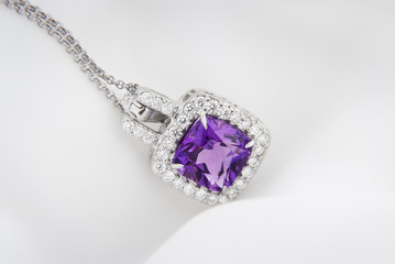 White gold pendant with rose violet amethyst and diamonds on soft  blurred background