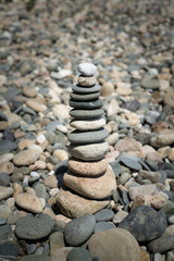 Fototapeta na wymiar Pyramid of pebbles on the beach, Pebble tower on the seaside, rocky beach