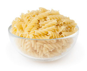 Uncooked fusilli pasta in glass bowl isolated on white background