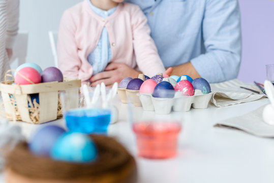 Painted Easter eggs on table in front of child and parents