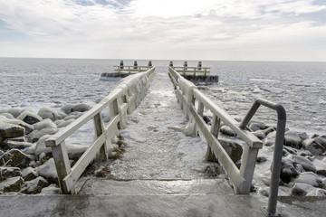 Beautiful frozenpier with icicles and rocks at a lake
