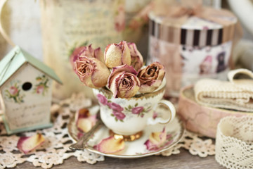 dried roses in vintage style porcelain cup