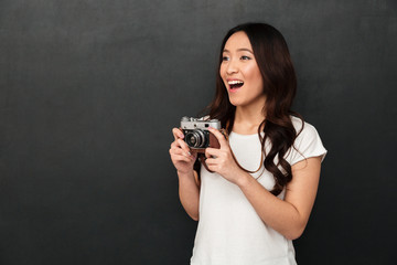 Excited woman photographer holding camera