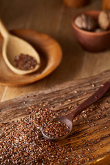 Wooden spoon with flax seeds on rustic background, top view, close-up, shallow depth of field, selective focus