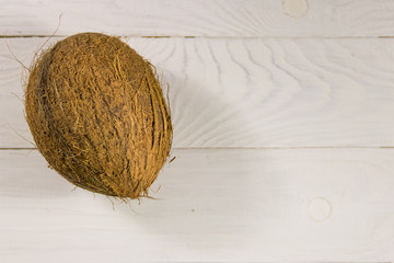 Whole coconut on white wooden table
