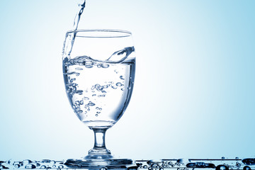 Pour drinking water into the glass with copy space