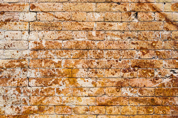 Background wall from an ancient yellow vintage brick with rusty corrosion patterns on the surface. Textured background in grunge style. Procurement for stylish graffiti