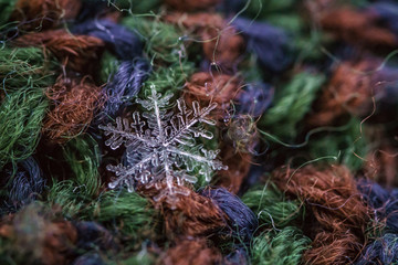 Beautiful detail of a snowflake, a single ice crystal in Paris winter, falls through the Earth's atmosphere as snow. Shining hexagonal crystals shape, used as a symbol of snow or crystal in science